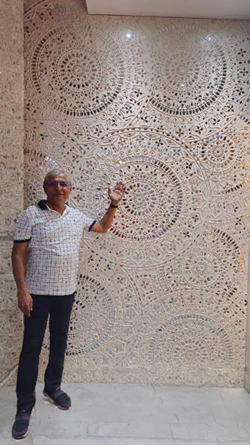 Dr. Mangesh Karandikar beside a large Kalaarang Lippan Art installation